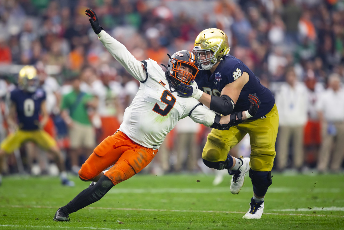 Jan 1, 2022; Glendale, Arizona, USA; Notre Dame Fighting Irish offensive lineman Joe Alt (76) defends against Oklahoma State Cowboys defensive end Brock Martin (9) in the 2022 Fiesta Bowl at State Farm Stadium.  
